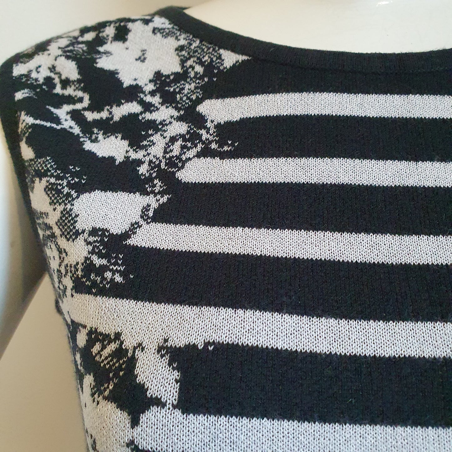 Robe graphique noir et blanc, gros plan épaule droite — détail du tissu jacquard rayures et fleurs — Élégance Intemporelle