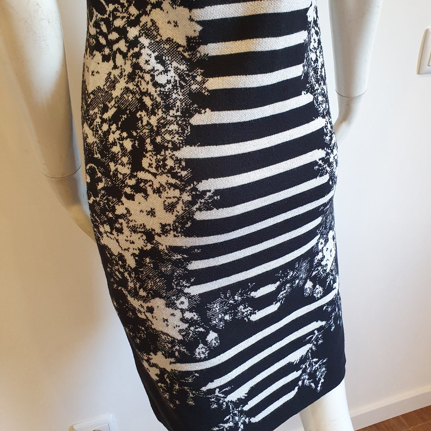 Robe graphique noir et blanc, vue profil arrière gauche — détail de la jupe et du motif jacquard en bas de robe — Élégance Intemporelle