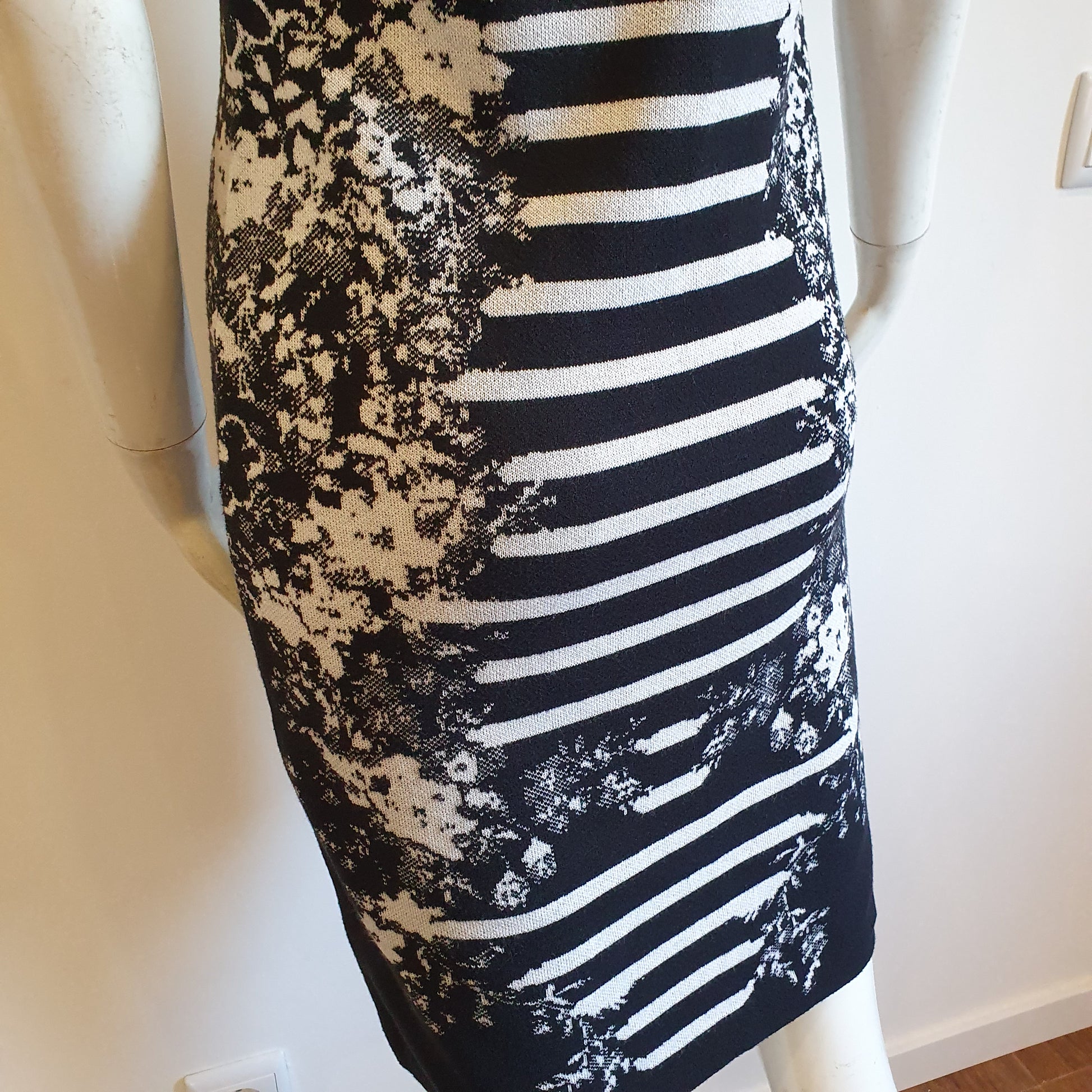 Robe graphique noir et blanc, vue profil arrière gauche — détail de la jupe et du motif jacquard en bas de robe — Élégance Intemporelle