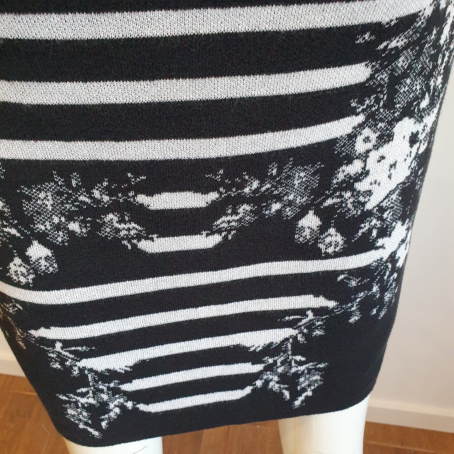 Robe graphique noir et blanc, vue de dos — détail de la jupe, motif jacquard rayures et fleurs en bas de robe — Élégance Intemporelle