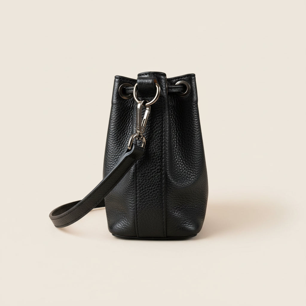 Sac bourse cuir grainé noir, vue de profil sur fond beige — Élégance Intemporelle