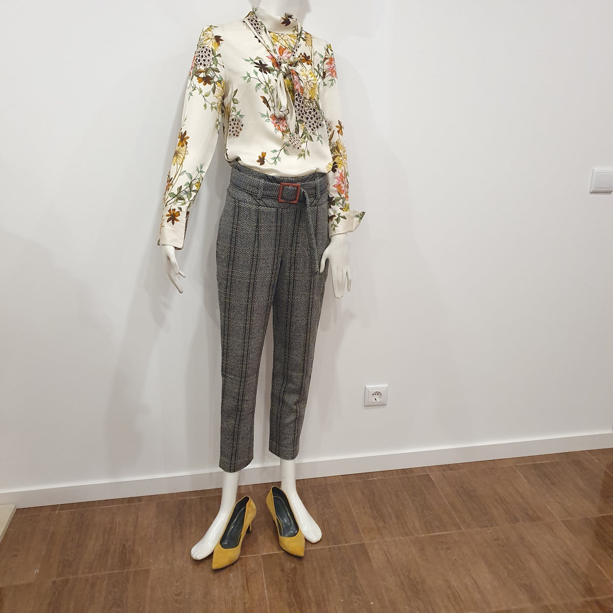 Chemisier fleuri Madeleine porté avec pantalon à chevrons gris et escarpins Moutarde