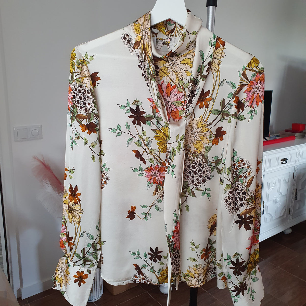 Vue complète sur cintre du chemisier à lavallière Madeleine, imprimé floral multicolore sur fond clair