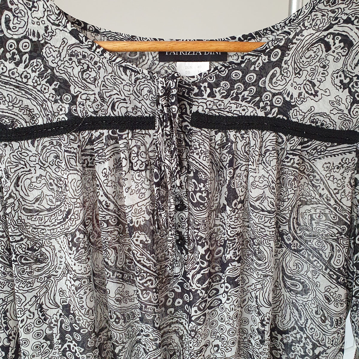 Encolure de la blouse Patrizia Dini avec liens à nouer, petits boutons noirs et étiquette de marque 