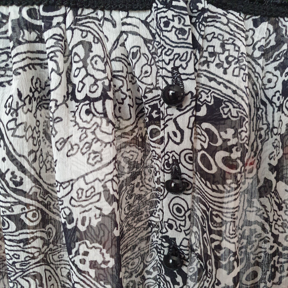 Petits boutons noirs de la patte de boutonnage de la blouse à imprimé cachemire 