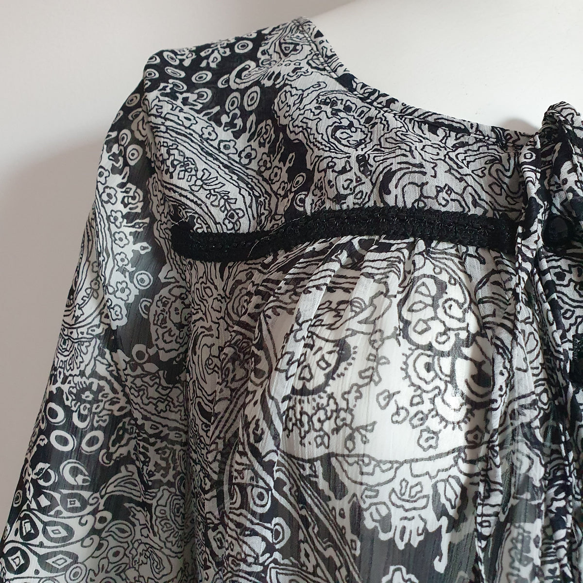 Galon noir perlé, fronces et transparence du voile à motif cachemire de la blouse Patrizia Dini