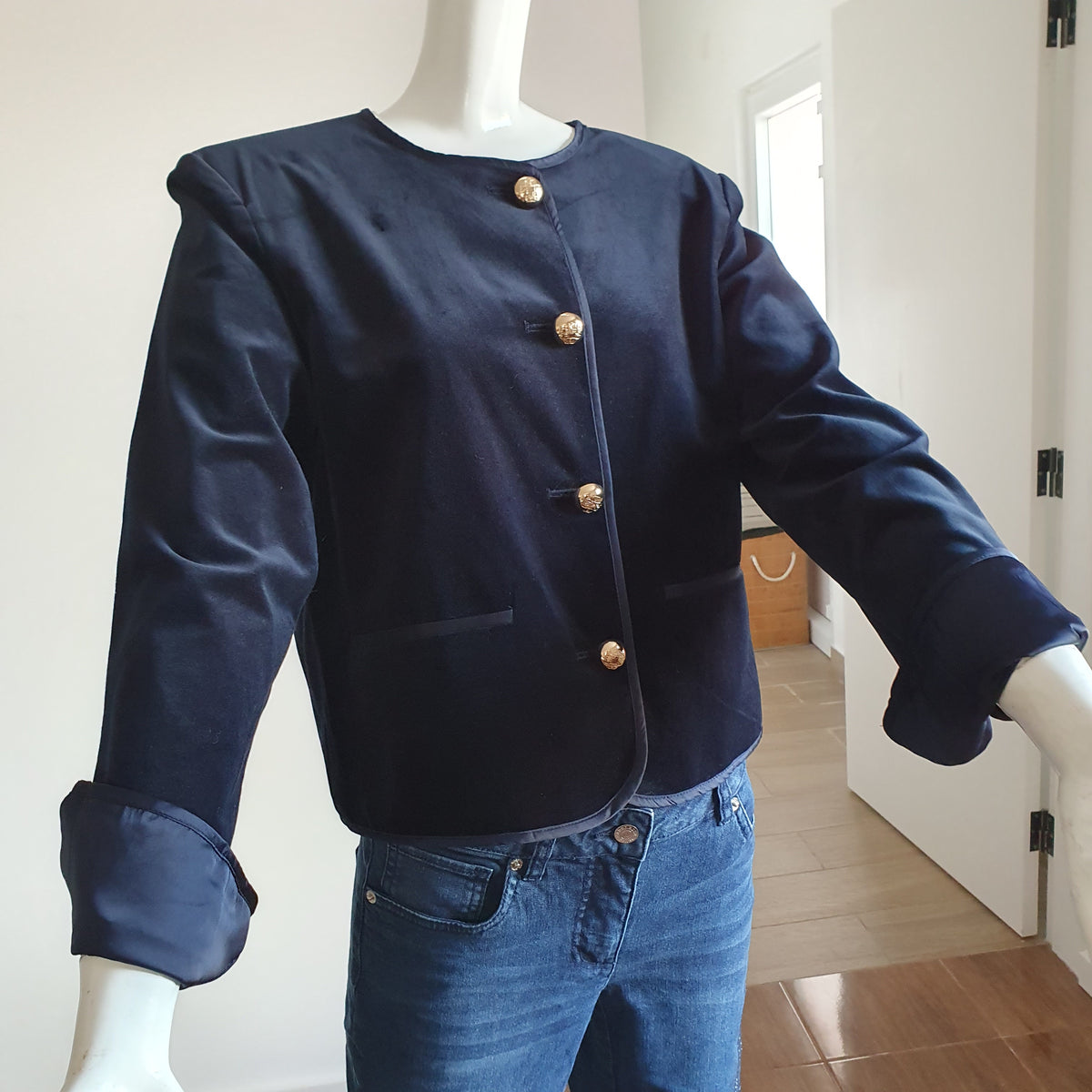 Veste en velours de coton bleu nuit sur mannequin, quatre boutons dorés et poignets retournés 