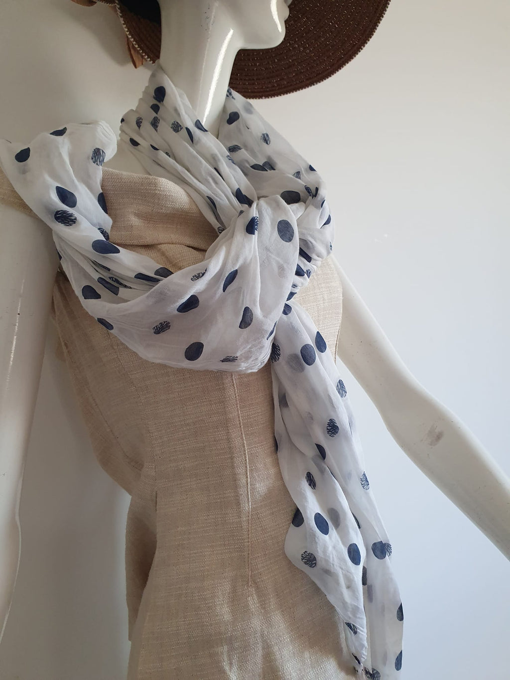 Foulard blanc à pois bleu marine - noué autour du cou