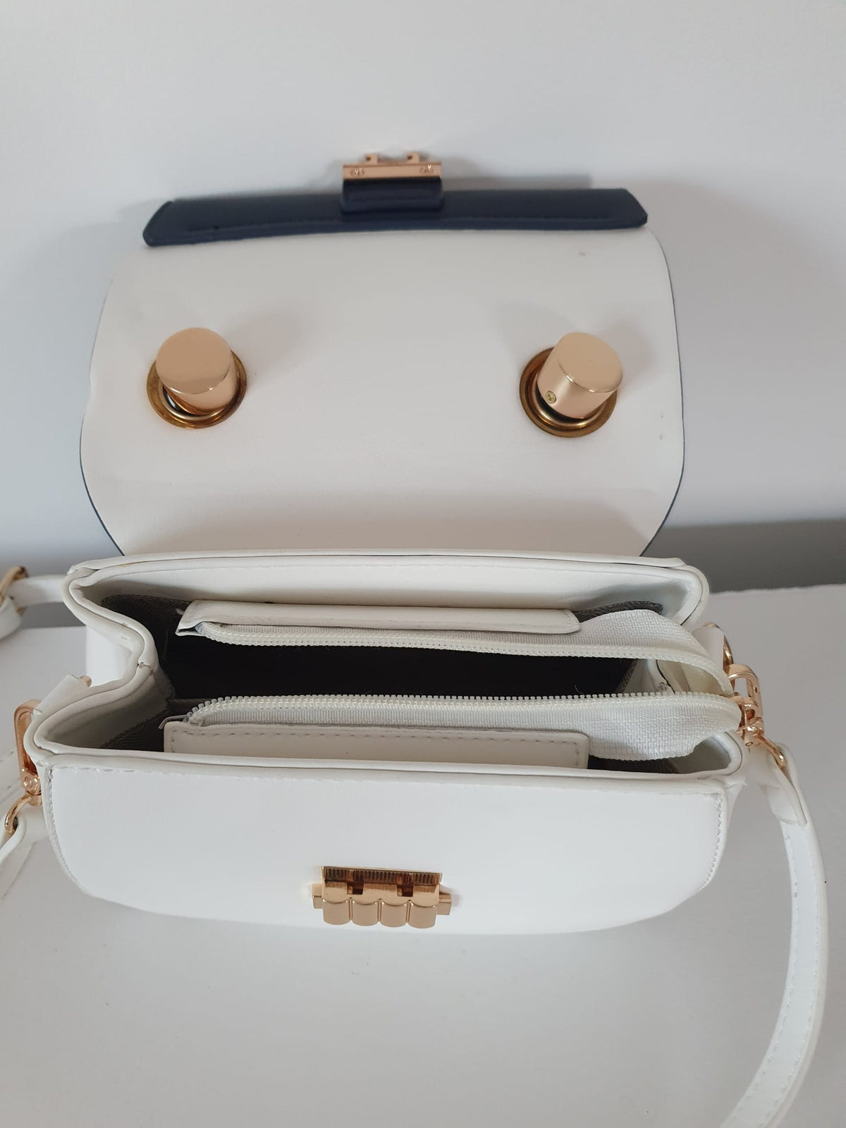 Sac à main bicolore blanc bleu marine — dessous du rabat ouvert, détail des 2 boutons-pression dorés, finition Art Déco