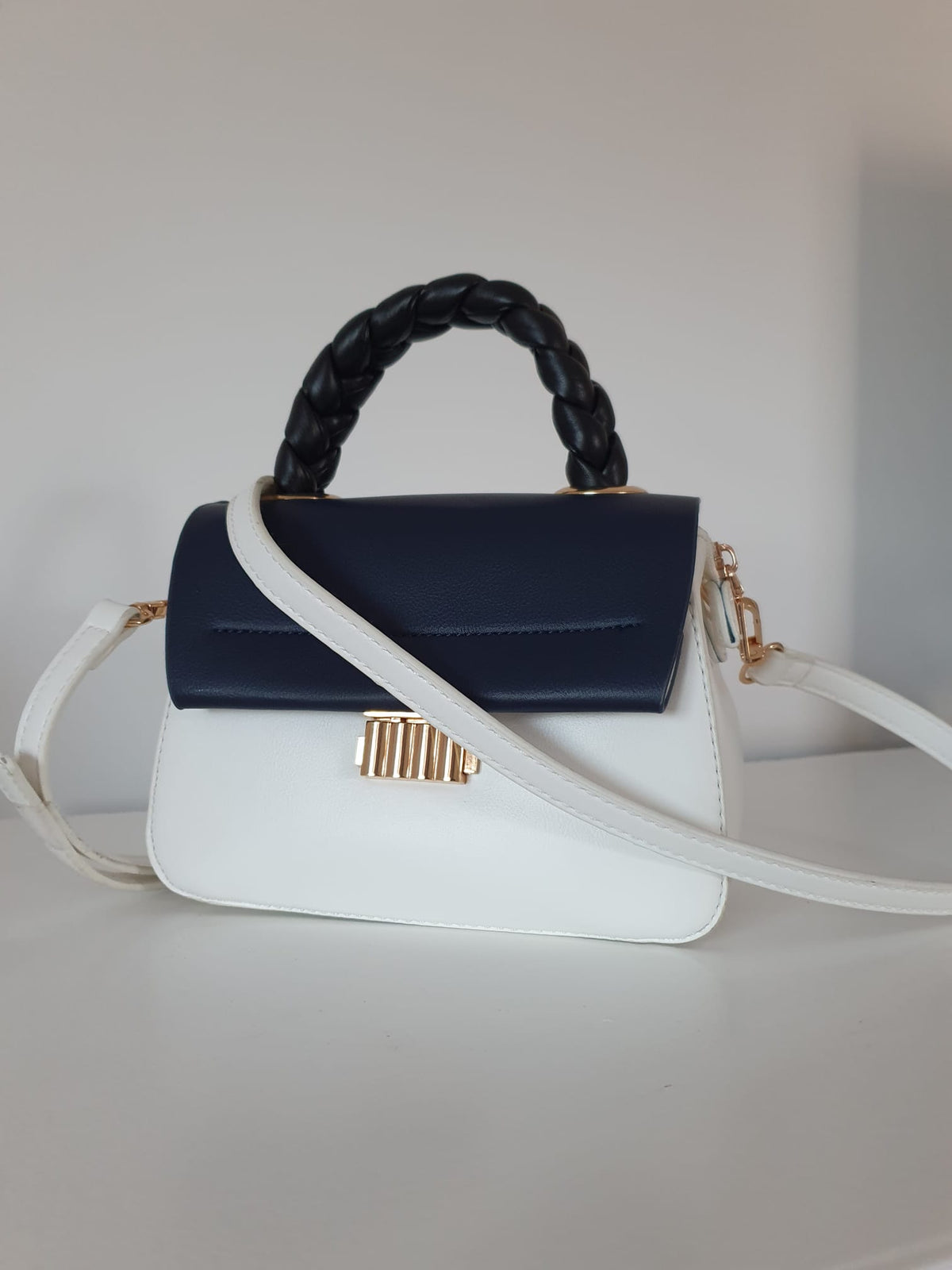 Sac à main bicolore blanc bleu marine — vue de face, bandoulière blanche réglable avec mousquetons dorés, style rétro chic