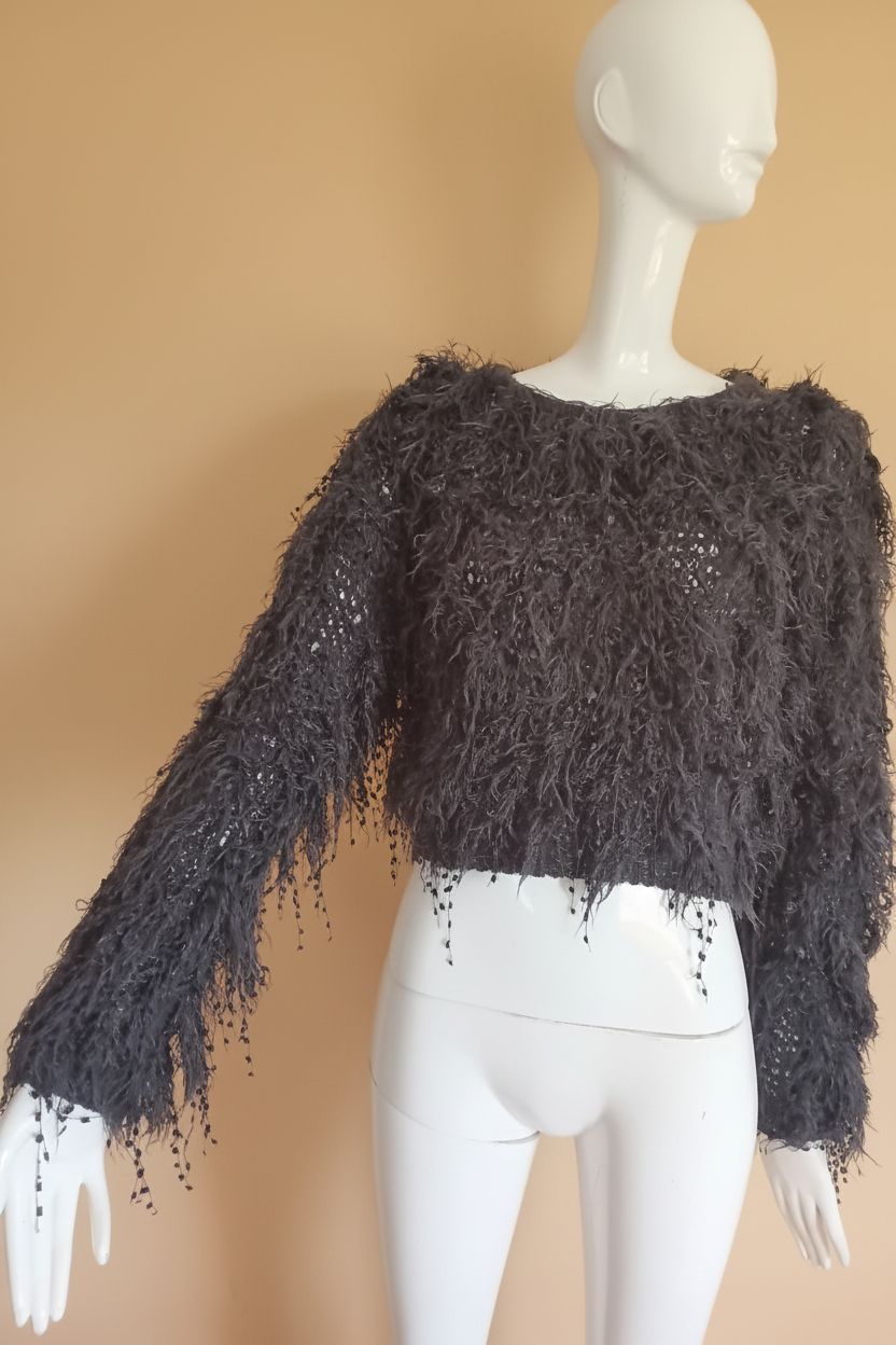Pull gris frangé fond beige