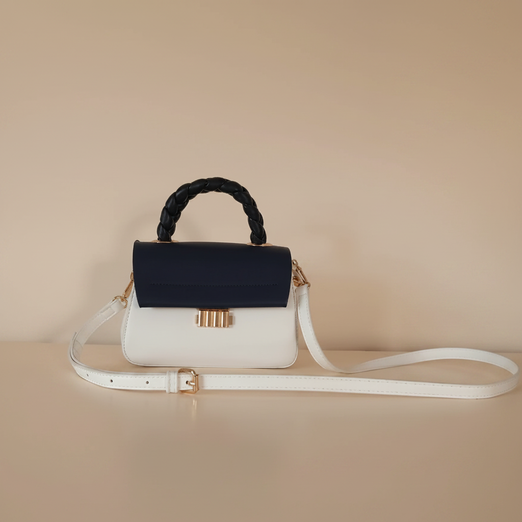 Sac à main bicolore blanc bleu marine — vue de face, anse tressée noire, clip doré Art Déco et bandoulière blanche, style rétro chic